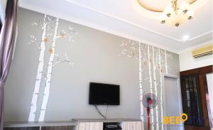 a living room with a tv and trees on the wall at Melaka Afamosa DAmour Villa 12PAX with Private Pool & BBQ in Kampong Alor Gajah