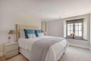 Un dormitorio blanco con una cama grande y una ventana. en Sea Chest, Salcombe Waterside Apartment, en Salcombe