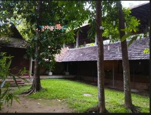 an outside view of a building with trees at AMBAT HOMESTAY in Kottayam