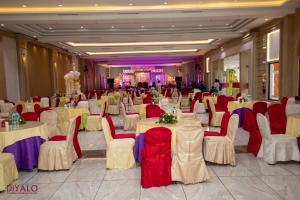 un salón de banquetes con mesas blancas y sillas rojas en Diyalo Foodland Chitwan, en Bharatpur