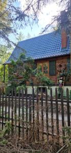 a wooden fence in front of a house at Dom wakacyjny in Nadkole
