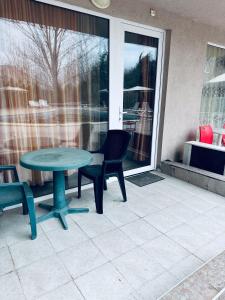 Un patio con una mesa y sillas y una ventana. en Stella Udacha Apartments & Studios, en Sunny Beach