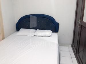 - un lit avec une tête de lit bleue et 2 oreillers blancs dans l'établissement RedLiving The Golf Apartement Modernland - Maria Room Tower Red, à Buaran