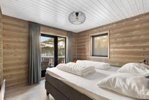 a bedroom with a large bed in a room with wooden walls at Stijlvolle vakantiewoning met uitzicht op het Vråvatn meer in Vradal