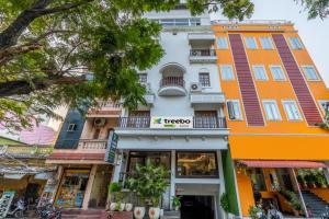 een oranje en wit gebouw met een winkel bij Treebo Trend Grace Inn 3 Min Walk From Promenade Beach in Pondicherry