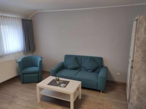 聖安德里斯伯格的住宿－Ferienwohnung Julius 7，客厅配有蓝色的沙发和桌子