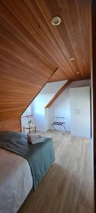 una camera con un grande letto e un soffitto in legno di Milladon Logement en face de l'EPFL a Ecublens