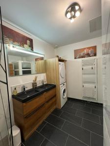een badkamer met een wastafel en een wasmachine bij Les Pénates de Camiers in Camiers