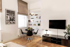 a living room with a table and a flat screen tv at Cosy 1 Bed Apartment in the heart of Mayfair! in London