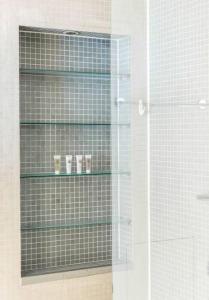 a glass shelf in a shower with cups on it at Cosy 1 Bed Apartment in the heart of Mayfair! in London