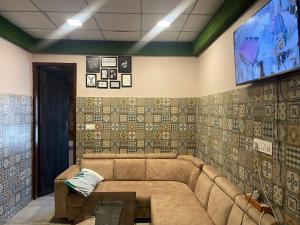 uma sala de estar com um sofá e uma televisão em Shiv shakti guest house em Bhiwāni