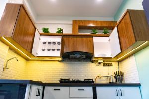 a kitchen with wooden cabinets and plants on the wall at Tranquill Riverside Luxury Cottages With Bathtub, Candolim in Candolim