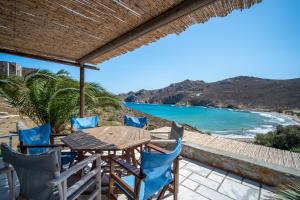 a table and chairs on a patio with a view of the ocean at Ammos 1 in Serifos Chora