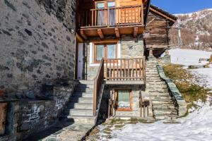 a house with stairs and a balcony on it at HelloChalet - Duplex Maison Loz with balcony in Valtournenche