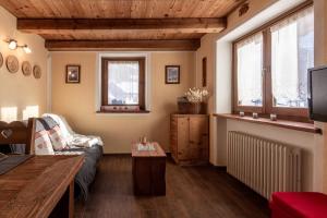 a living room with a couch and a tv at HelloChalet - Duplex Maison Loz with balcony in Valtournenche