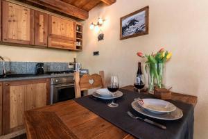 a kitchen with a table with two glasses of wine at HelloChalet - Duplex Maison Loz with balcony in Valtournenche