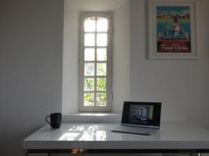 a laptop sitting on a table in front of a window at Apartment Picasso in großem Park mit geheiztem Pool in Châteauneuf
