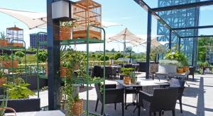 a patio with tables and chairs and plants at Van der Valk Hotel Eindhoven in Eindhoven