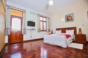 a bedroom with a bed and a flat screen tv at Lidia's Place Guest House in Maputo