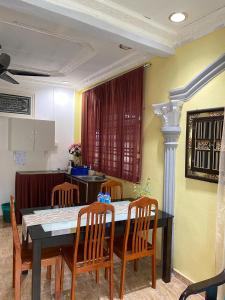 a dining room with a table and chairs at Teratak Tiga Homestay Padang Besar in Kaki Bukit