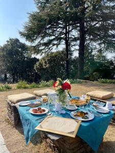 uma mesa azul com pratos de comida em Tree of Life Grand Oak Manor Binsar em Binsar