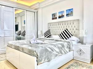 um quarto branco com uma cama e um espelho em Alexandria Luxury Apartments Stanley Direct Sea View em Alexandria