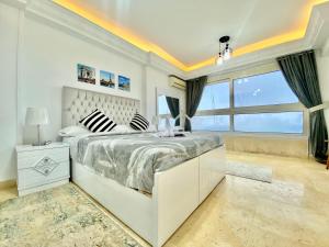 a white bedroom with a large bed and a window at ALEX HOMES - Stanley Cozy Apartments with Direct Sea View in Alexandria