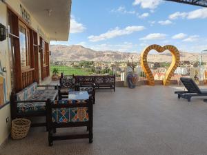 a balcony with chairs and a heart arch in the background at Thebes Hotel in Luxor