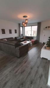 uma sala de estar com um sofá e uma mesa em Vakantiehuis Horsterwold em Zeewolde
