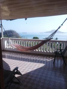 a hammock on a balcony with a view of the ocean at La casa de Wili Taboga 62,61,00,07 in Taboga