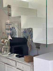 a living room with a tv and a lamp on a dresser at VILLA LE AGAVI Luxory Beach Surfhouse in Bellaria-Igea Marina