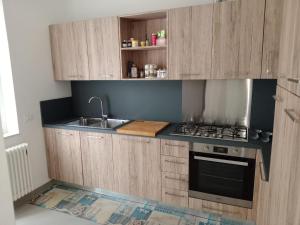 una cocina con armarios de madera y fregadero en CASA LEDA, en Pescara