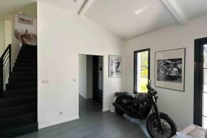 a motorcycle parked in a room with a staircase at Maison du Lac avec Lagon, Spa de Nage, Jacuzzi in Biscarrosse +44 photos