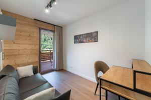 a living room with a couch and a table at Quintessence - Apt A201 - BO Immobilier in Châtel