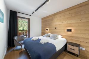 a bedroom with a large bed with a wooden wall at Quintessence - Apt A201 - BO Immobilier in Châtel