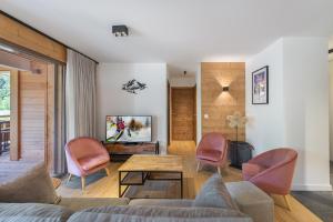 a living room with a couch and chairs and a tv at Quintessence - Apt A201 - BO Immobilier in Châtel