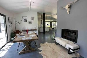 a living room with a table and a fireplace at Maison du Lac avec Lagon, Spa de Nage, Jacuzzi in Biscarrosse