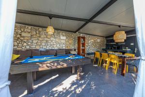 uma sala de jantar com mesas e cadeiras e uma parede de pedra em Villa mit Privatpool, Whirlpool, 350 Meter zum Strand em Dramalj