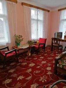 un salon avec des chaises et un tapis rouge dans l'établissement La 2 pași de Biserica Neagră, à Braşov 2 autres photos