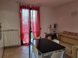 - un salon avec une table et des rideaux rouges dans l'établissement Casa Il Cipresso, à Sant'Albino