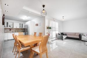 a kitchen and dining room with a wooden table and chairs at LuxuryApt/BestView/PerfectForFamilies/FreeParking in Eilat