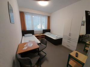 a small room with a table and a bed at Internationales Gästehaus in Jena