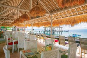 um restaurante com cadeiras e mesas e vista para o oceano em Kura Kura Resort Gili Meno em Gili Meno