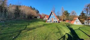 dom na polu trawy z płotem w obiekcie Kolorowe Wzgórze Zagórze w Zagórzu Śląskim