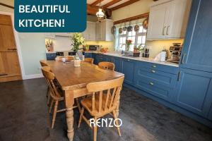 a kitchen with a wooden table and blue cabinets at Homely 4-bed Home in Nottingham by Renzo, Peaceful Location, Sleeps 8! in Burton Joyce