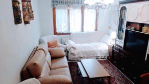 a living room with a couch and a tv at CASA JUNTO AL PARQUE NATURAL DE LAS BARDENAS in Sádaba