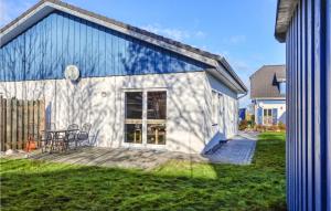 een blauw-wit huis met een tafel en stoelen bij Ferienhaus 41 Altefhr in Altefähr