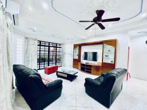 a living room with two couches and a ceiling fan at SingHome Holiday House in Mersing