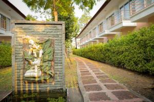 a statue of two women on a wall next to a building at Kiatthada Resort in Bangkok