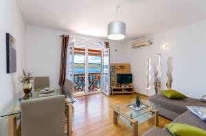 ein Wohnzimmer mit einem Sofa und einem Tisch in der Unterkunft Balkon mit Meerblick direkt am Strand in Jadranovo